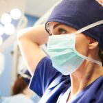 young female surgeon tying her surgical mask