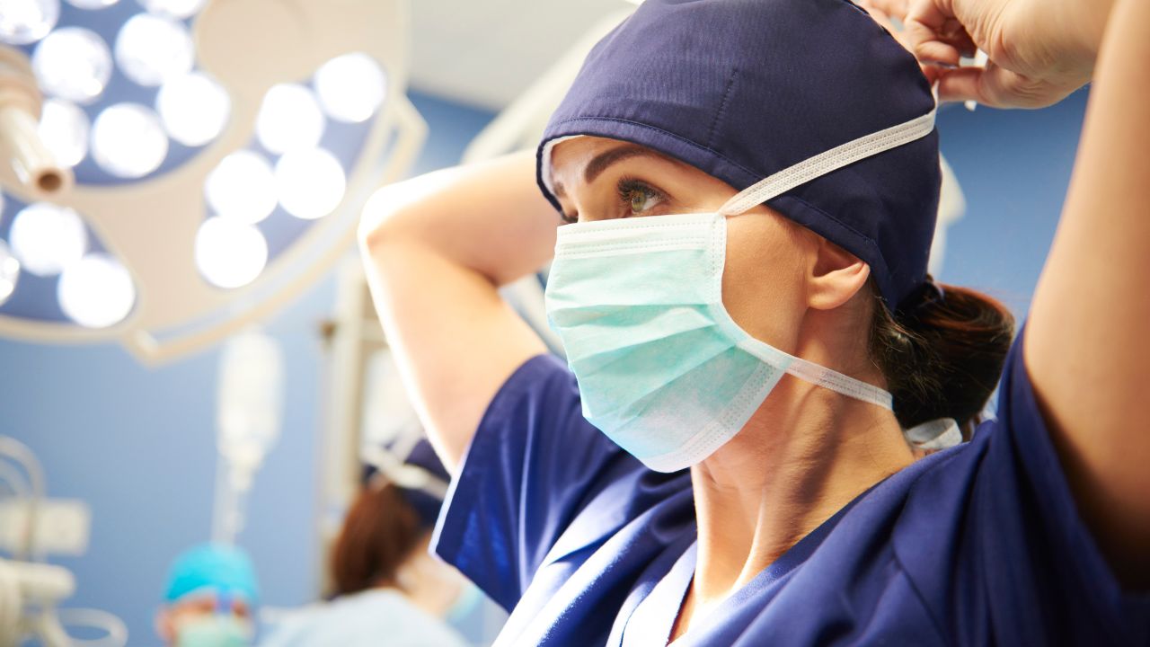 young female surgeon tying her surgical mask